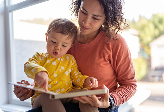 A woman sitting with a child reading a book